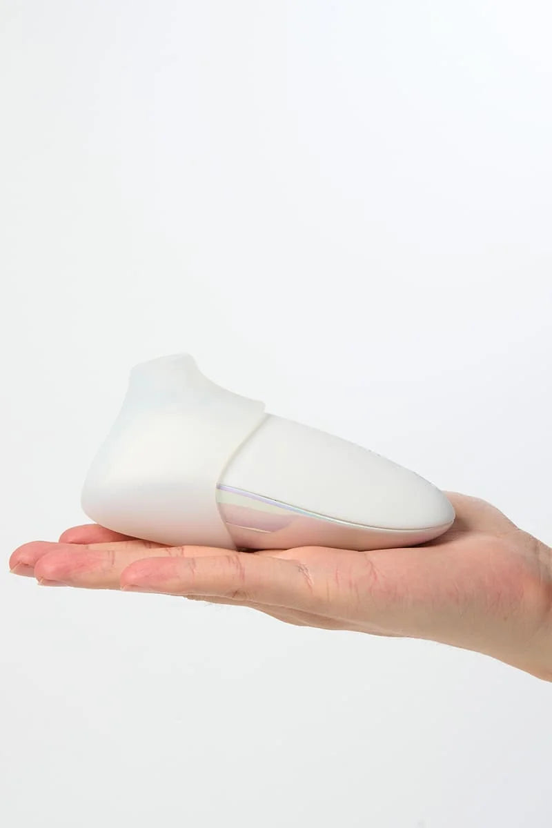 White Myvelvettouch Colorful Clitoral Slapping Massager held in a hand against a white background