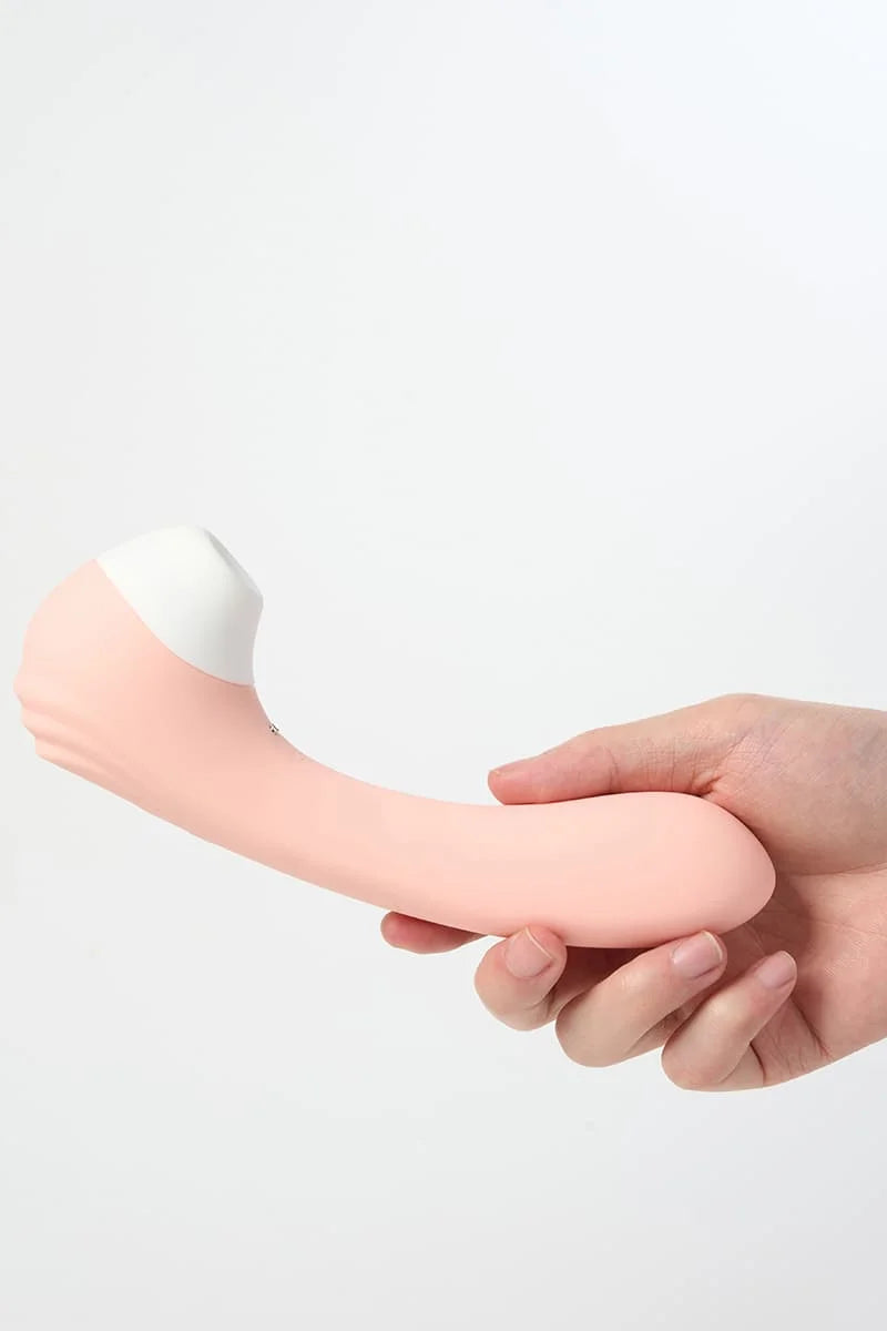 Pink and white silicone Myvelvettouch Portable 2-in-1 Female Sucking and Vibrator held by hand on a light gray background