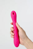 Hand holding a pink Myvelvettouch Portable Clitoral Suction and Vibrator 2-in-1 against a light gray background