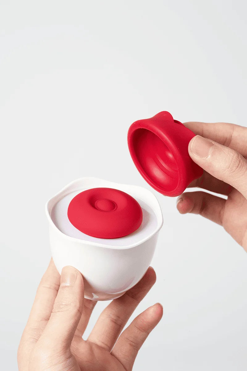 Myvelvettouch Rose Pot Clitoral Sucking and Slapping Stimulator held by a hand against a light gray background