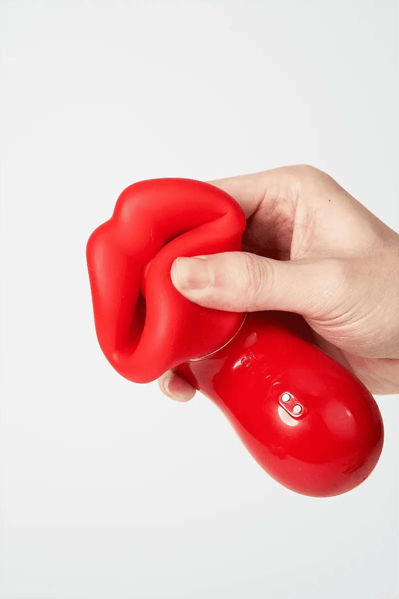 Myvelvettouch Sexy Red Lips Sucking Tongue Licking Vibrator being held in a hand against a white background