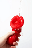 Myvelvettouch Sexy Red Lips Sucking Tongue Licking Vibrator being held with water dripping from it on a white background