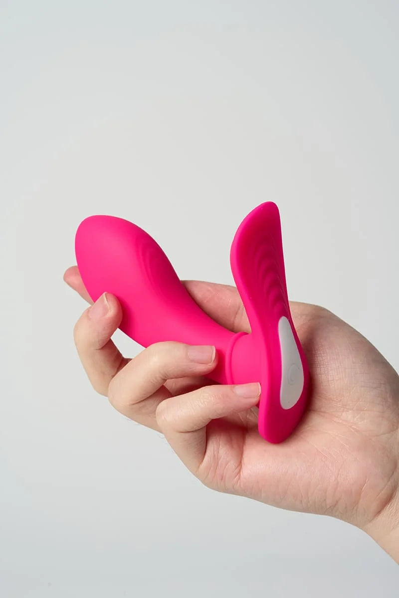 Myvelvettouch Women’s Thin Wearable Vibrator and Remote Control held in a hand against a light gray background