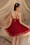 Woman wearing a red Myvelvettouch lace nightgown in a softly lit room.