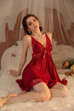 Woman in a red Myvelvettouch dress sitting on a bed with a canopy