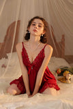 Woman wearing a red Myvelvettouch lace nightgown in a softly lit room.