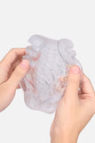 Clear silicone containter of Suction Cup Automatic Sucking Vibration Voice Aircraft Cup held by two hands on a white background
