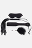 Black leather blindfold, paddle, and flogger on a white background