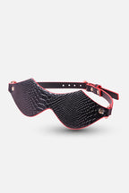 Black and red eye mask with textured surface on a white background