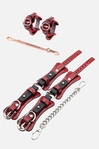 Red and black leather restraints handcruffs with chains on a white background