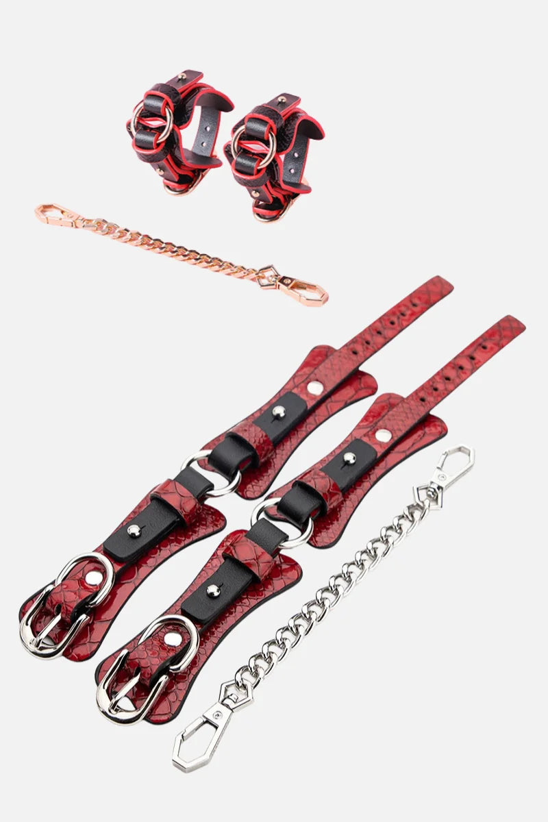 Red and black leather restraints handcruffs with chains on a white background