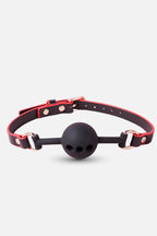 Black ball gag with red leather strap on a white background