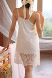 Woman wearing a white Myvelvettouch lace nightgown in a softly lit room.