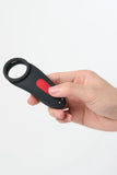 Hand holding a black and red Myvelvettouch Couples Vibrating Ring with Remote Control against a white background