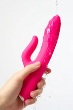 Pink Myvelvettouch G-spot Tapping and Clitoral Stimulation Vibrator held by a hand against a white background