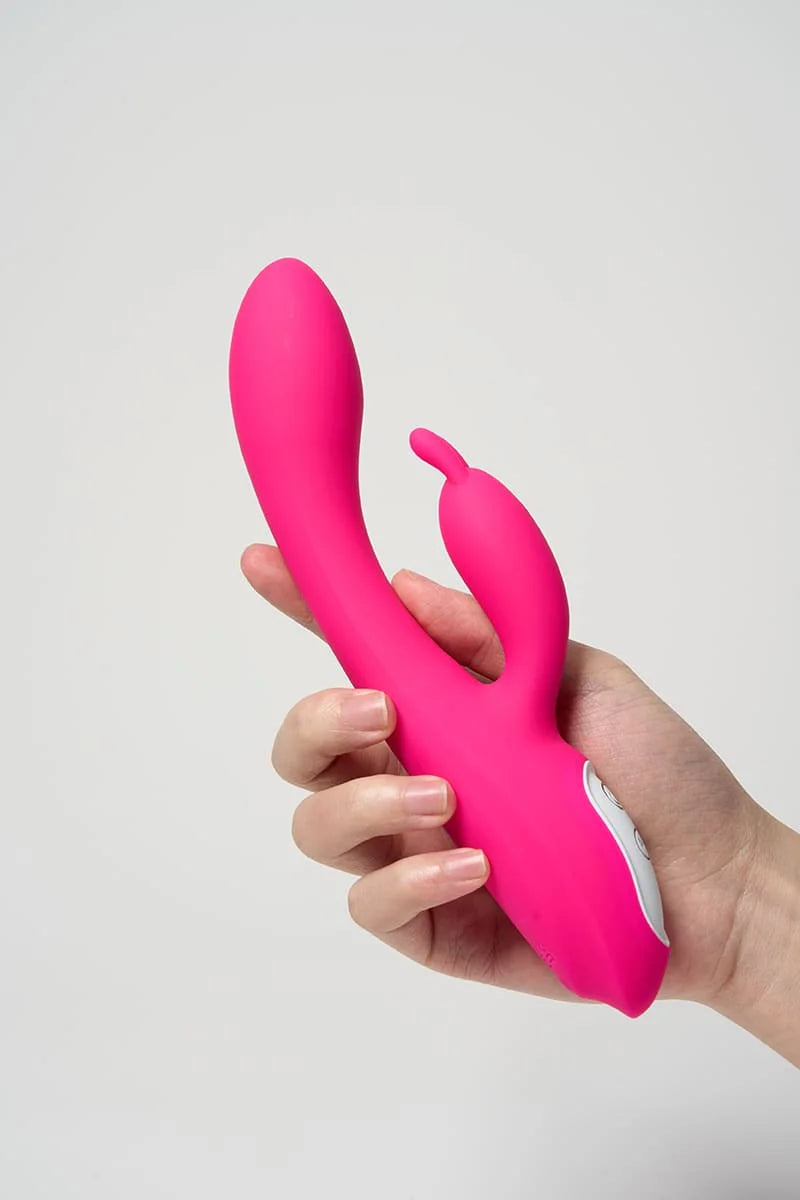 Hand holding a pink Myvelvettouch Heated Rabbit Vibrator against a light gray background