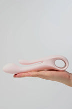 Pink Myvelvettouch Multifunctional Clitoral Stimulator Dual Head Vibrator held in a hand against a light gray background