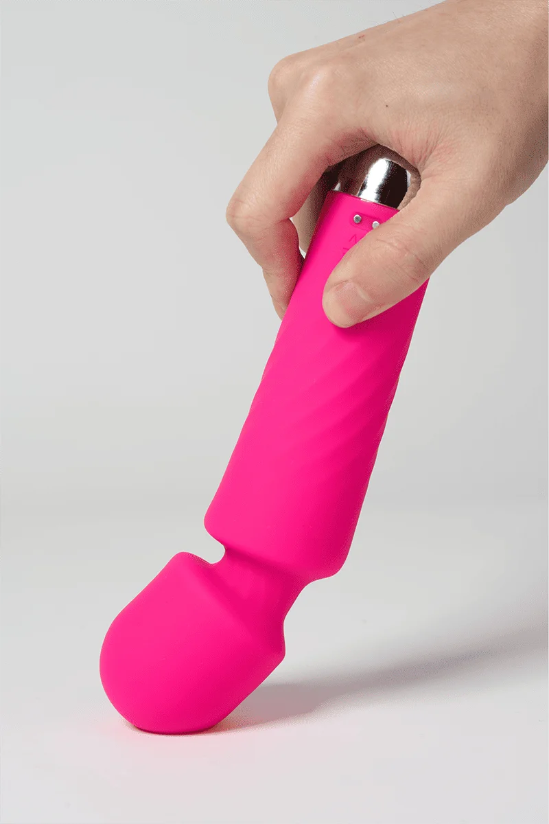Myvelvettouch Portable Clitoral Stimulator Massager with a silicon top held by a hand on a light gray background