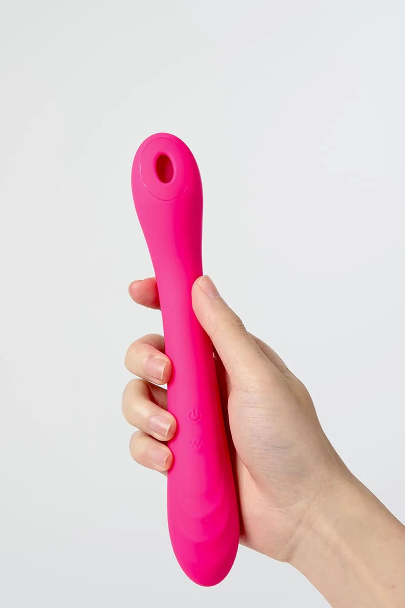Hand holding a pink Myvelvettouch Portable Clitoral Suction and Vibrator 2-in-1  against a light gray background