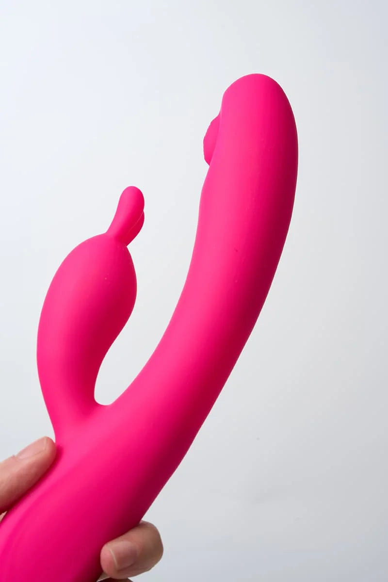 Pink Myvelvettouch Rabbit Clitoral Stimulation and G-spot Slapping Vibrator held by a hand against a white background