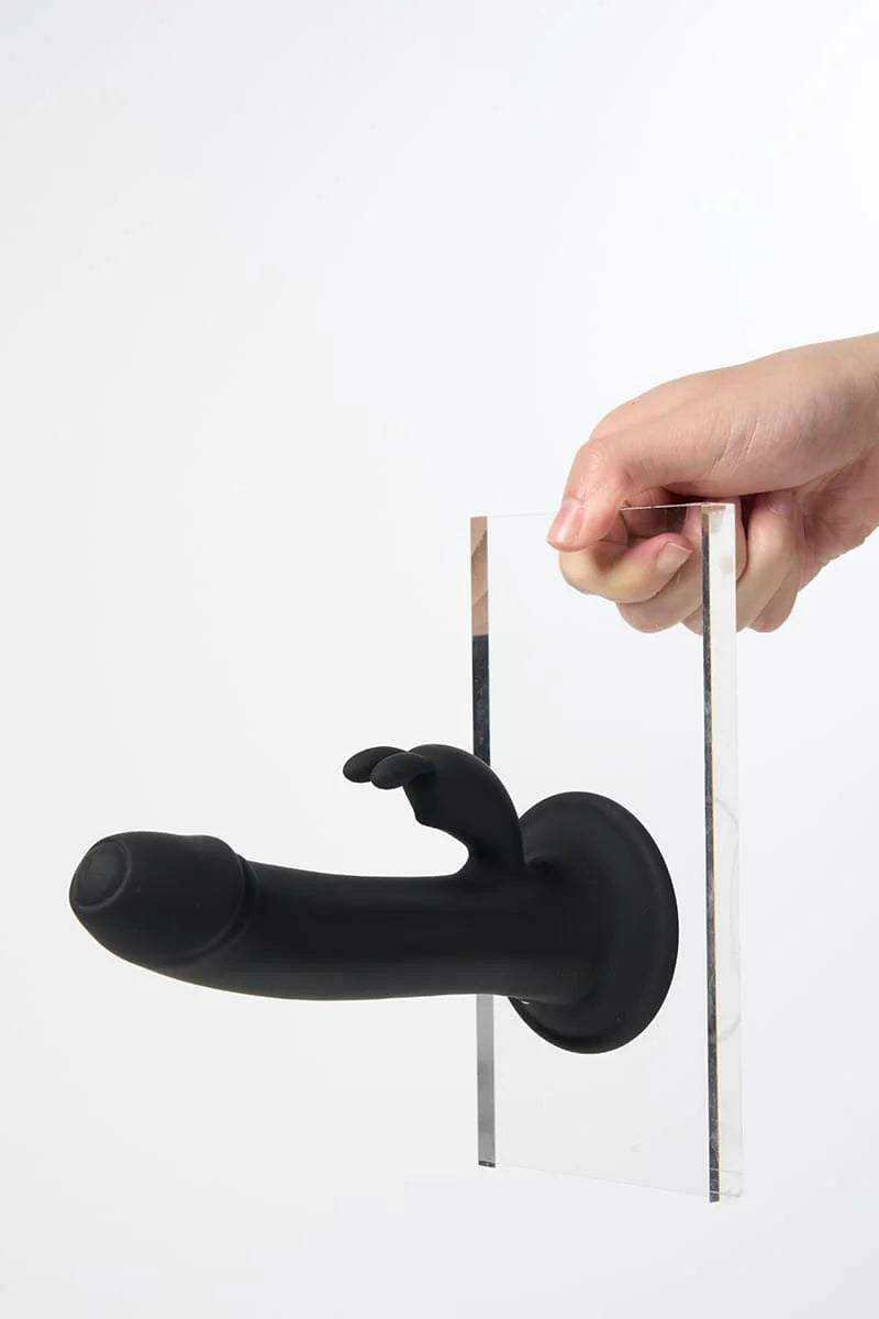 Black Myvelvettouch Rabbit Suction Cup Dildo with a hand holding it against a white background