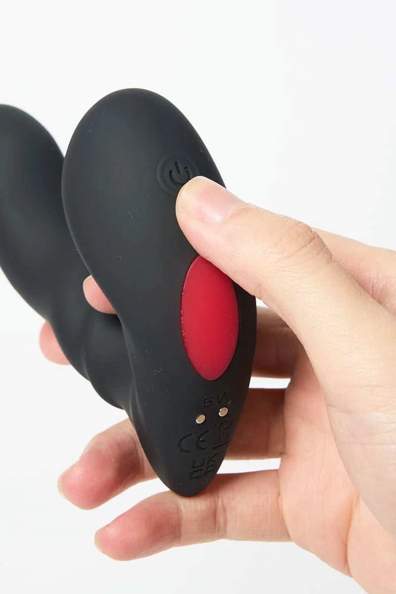 Black and red Myvelvettouch Unisex Prostate Vibrator held in a hand against a white background