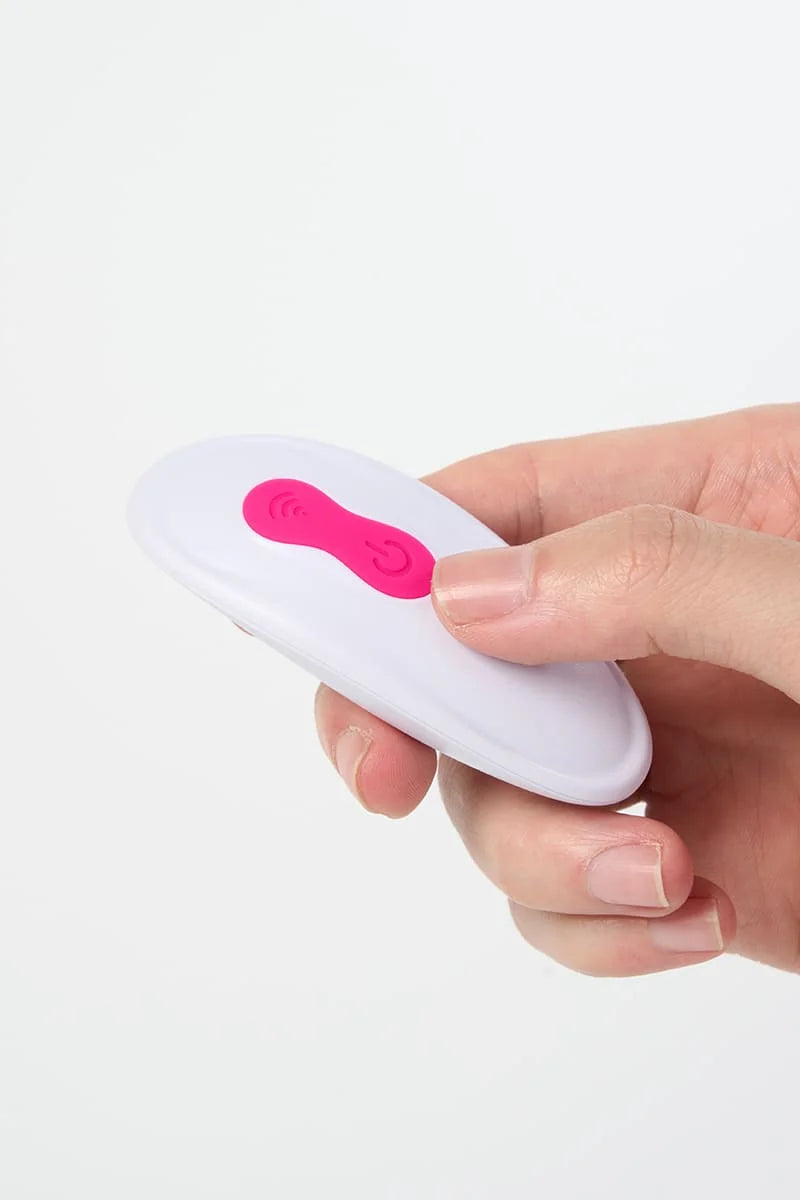 Hand holding a small white remote control of Myvelvettouch Wearable Clitoral Sucking Vibrator on a white background