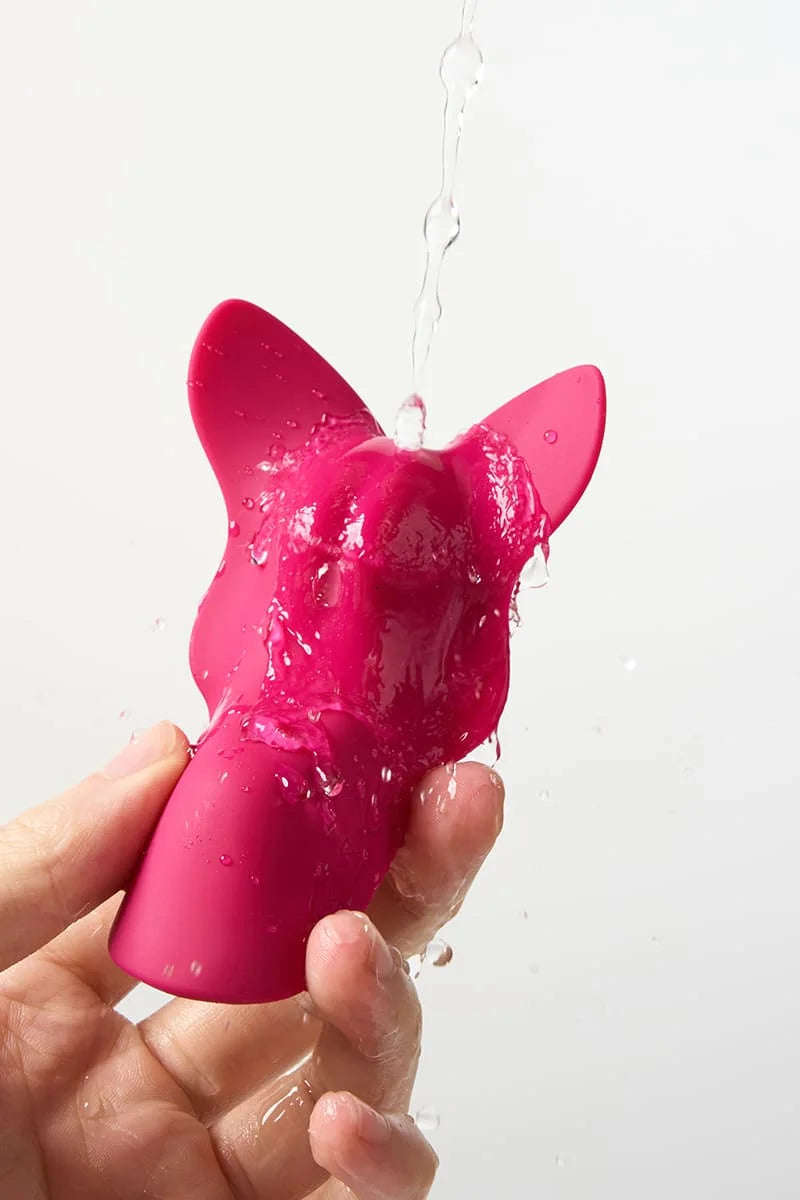 Pink Myvelvettouch Remote control sex toys Panty Vibrator being held with water droplets on a white background