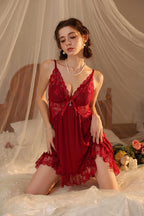 Woman wearing a red Myvelvettouch lace nightgown in a softly lit bedroom setting.