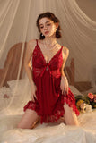 Woman wearing a red Myvelvettouch lace nightgown in a softly lit bedroom setting.