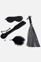 Set of Black Feather Teaser BDSM Role Play Kit – 4 Piece Set including a blindfold, paddle, feather duster, and flogger on a white background.