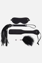 Black leather blindfold, paddle, and flogger on a white background