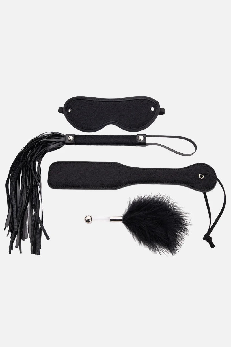 Black leather blindfold, paddle, and flogger on a white background Main image