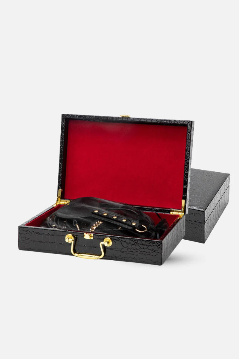 Black leather belt with gold buckle in an open black box with red interior on a light gray background, belong to myvelvettouch Luxury Leather BDSM Role Play Kit with Storage Case