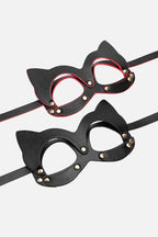 Black cat-eye masks with gold studs on a white background