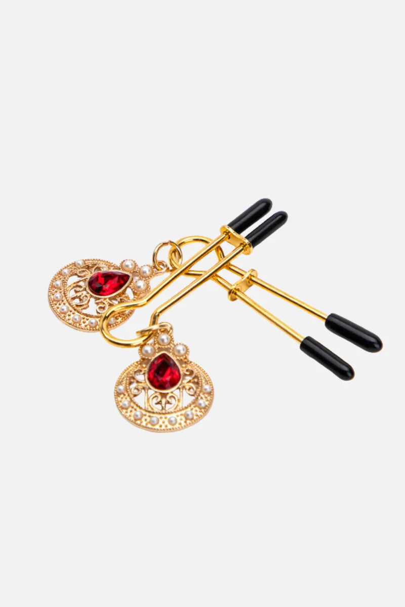 Pair of gold ring with red gemstones on a white background